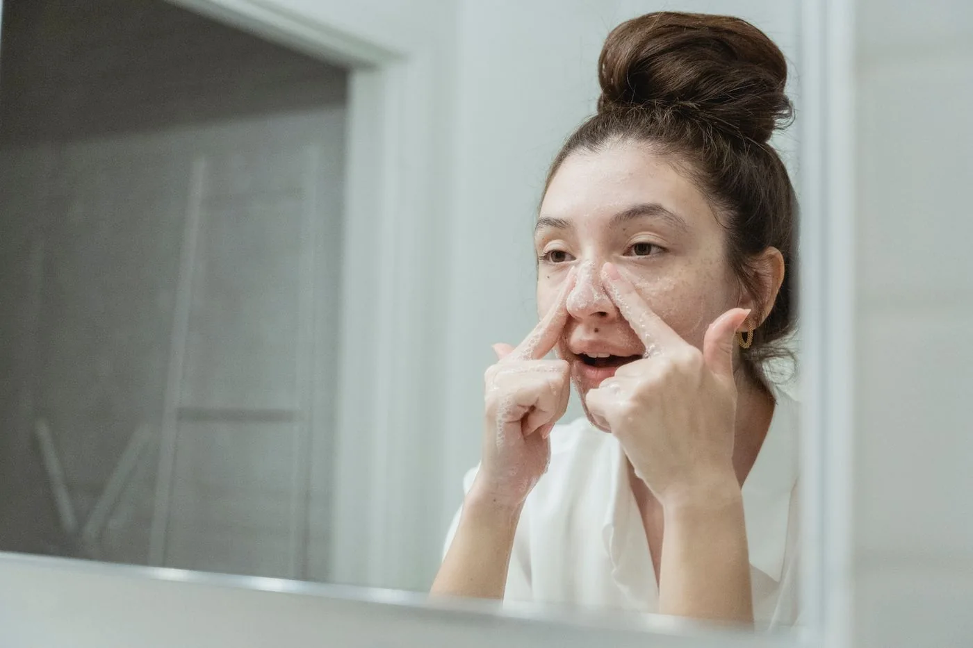 Woman washing her face at a bathroom sink