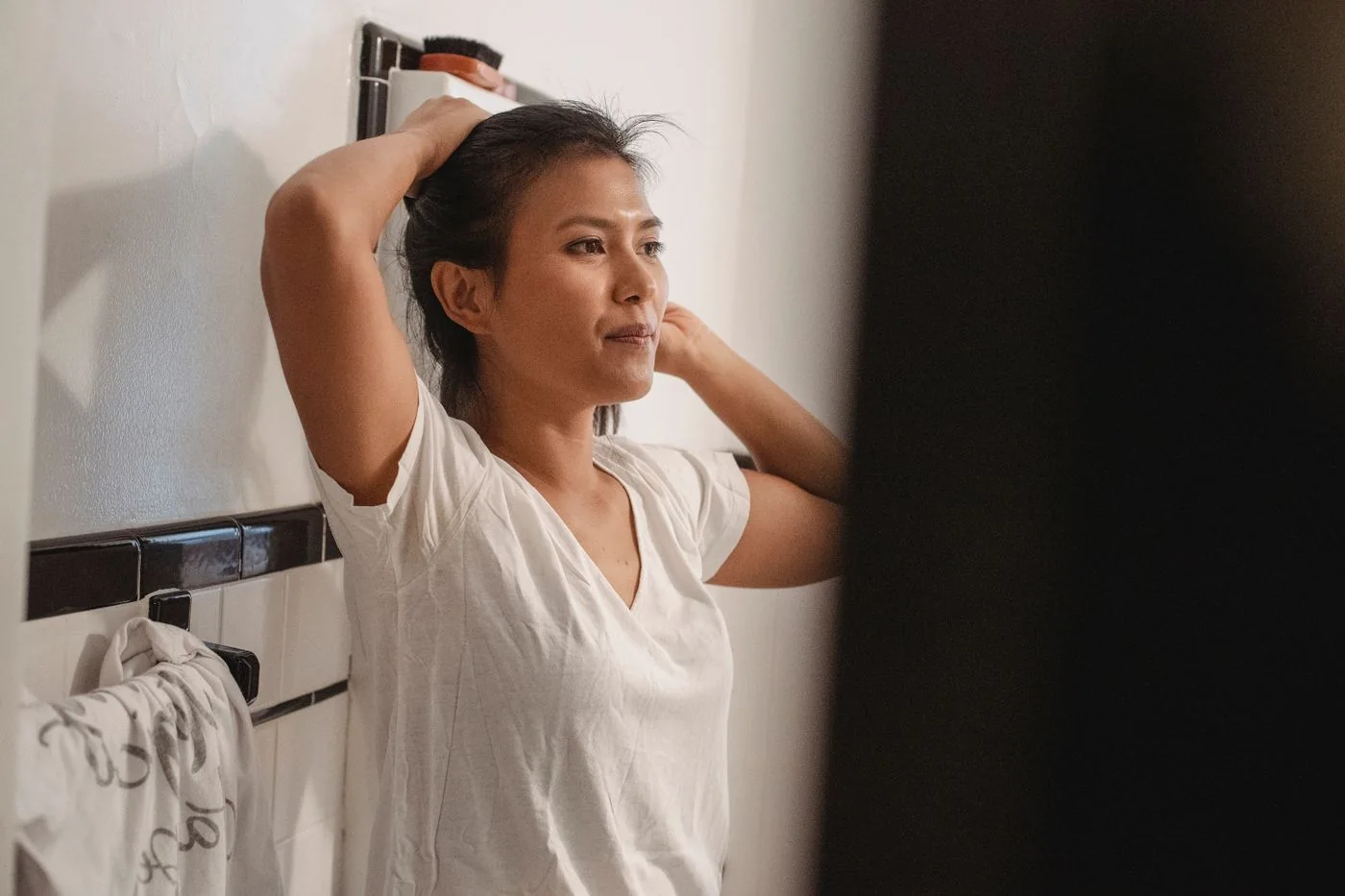 Woman arranging her hair in a bathroom